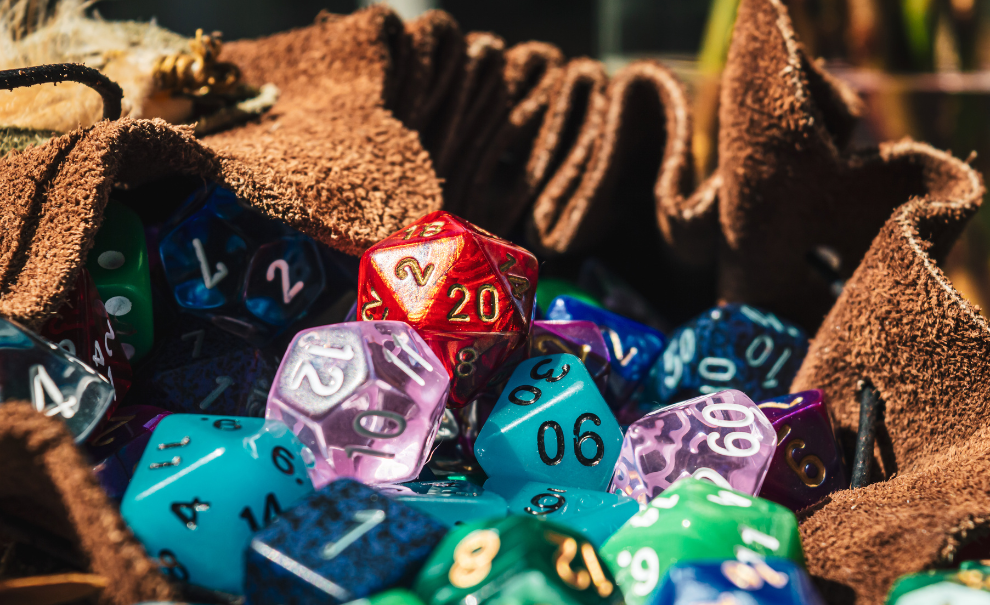 A bunch of various polyhedral dice in a brown cloth bag.