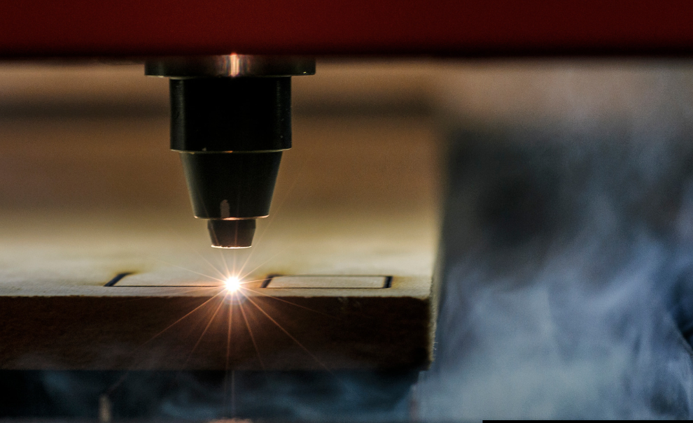 A laser cutter engraving a piece of wood